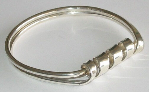 Bracelet by Anna Greta Eker for PLUS, twirling silver lines creating a flecible yet structured piece of Scandinavian Mid Century Modern Jewelry.