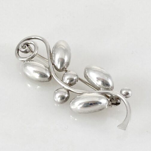 Brooch by Hermann Siersbøl, in silver with a stylized naturalistic motif. The company was founded in 1945 at Kastrup in Denmark, and we see in the brooch a traditional motive elements from nature, somehow stylized and modernized, and thus pointing towards the future of jewelry.