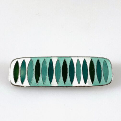 Green brooch by Hannelore Sorge, made in matte enamel. By use of Sorge's very distinct style she makes a weighty and lasting contribution to Scandinavian Mid Century Modern jewelry.