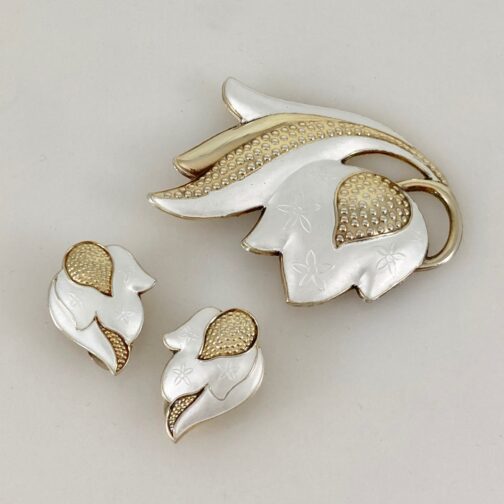 Brooch and earrings by J. Tostrup. The set is in silver gilt and delicately designed with pattern beneath the enamel. The piece is rooted in tradition with a simplicity in shape that seems to point ahead to more modern times.